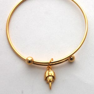 Pulsera rígida con dije de cangrejo herradura - oro