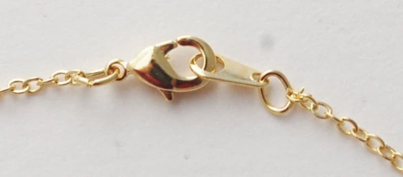 May include: A gold-toned chain necklace with a lobster clasp closure.