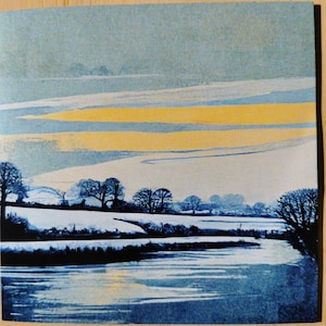 May include: A winter landscape painting with a river in the foreground. The river is covered in ice and snow, and the water is a deep blue. The sky is a light blue with streaks of yellow, and there are trees in the background.