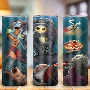 Op de afbeelding: Een set van drie roestvrijstalen bekers met afbeeldingen van personages uit de film The Nightmare Before Christmas. De bekers zijn versierd met afbeeldingen van Jack Skellington, Sally, Zero en Oogie Boogie.