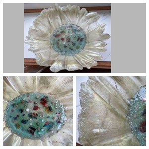 May include: A white resin bowl with a scalloped edge and a center filled with colorful glass pieces. The bowl has a light, airy feel and would be perfect for displaying small items.