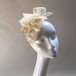 May include: A white, delicate, and intricate hat with a floral design. The hat is made of a soft, lightweight material and is perfect for a special occasion.