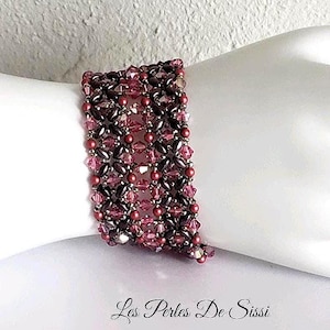 May include: A wide beaded cuff bracelet featuring a repeating lattice pattern of dark purple and light pink faceted crystals, accented with small round beads. The text Les Perles De Sissi is printed in black script at the bottom of the image.