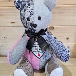 Pu&ograve; includere: Un orsacchiotto di pezza fatto di diversi tessuti, tra cui grigio, rosa e blu. L'orso ha un papillon nero e una toppa a forma di cuore con il testo "We never got to meet you. We love you very much. Love Great Nana and Grandpa".