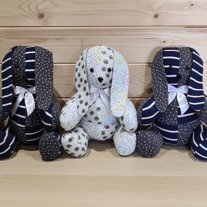 Pu&ograve; includere: Cinque giocattoli di peluche a forma di coniglio fatti a mano con orecchie lunghe. I conigli sono fatti di diversi tessuti, tra cui motivi a righe e floreali in tonalit&agrave; di blu, bianco e nero.