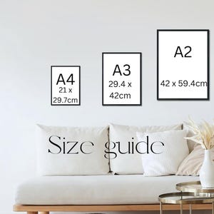 May include: Three framed art prints in black frames, labeled A4 (21 x 29.7cm), A3 (29.4 x 42cm), and A2 (42 x 59.4cm), against a white wall. Below, a white couch with pillows and the words "Size guide".