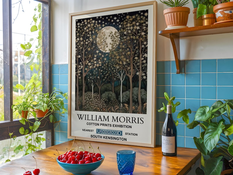 May include: A framed poster with a vintage aesthetic featuring a moonlit forest scene with gold and blue tones. The poster text reads "William Morris Cotton Prints Exhibition Nearest Underground Station South Kensington".