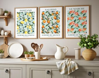 May include: Three framed prints with a white background and green leaves. The prints feature illustrations of lemons, oranges, and peaches with the Italian words "Albero di Limoni", "Albero di Arance", and "Albero di Pesche" printed below the illustrations.
