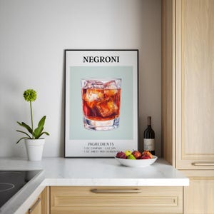 Può includere: Un poster stampabile con un design minimalista che presenta un bicchiere di cocktail Negroni con cubetti di ghiaccio. Il poster ha il titolo "Negroni" e elenca gli ingredienti: 1 oz di Campari, 1 oz di Gin, 1 oz di Vermouth rosso dolce.