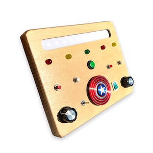 May include: A wooden panel with a light strip, various colored buttons, a red and blue star-shaped button, and two black knobs.