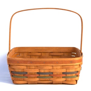 Könnte beinhalten: Ein brauner geflochtener Korb mit einem Griff. Der Korb hat eine rechteckige Form und ist aus natürlichen Materialien gefertigt. Der Korb hat ein buntes Streifenmuster am oberen Rand.