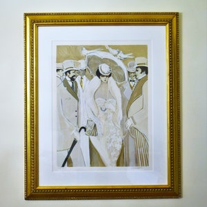 May include: A framed print of a vintage illustration featuring a woman in a white dress and hat, surrounded by men in suits and hats. The print is in a gold frame with a white mat.