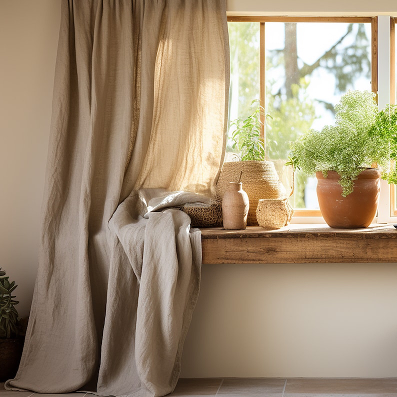 K&ouml;nnte beinhalten: Ein Fenster mit einer Holzbank und einem beigefarbenen Leinenvorhang. Das Fenster ist mit Topfpflanzen, einem geflochtenen Korb und einer Terrakottavase dekoriert.