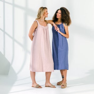 Pu&ograve; includere: Due donne che indossano abiti estivi casual. La donna a sinistra indossa un abito rosa chiaro e la donna a destra indossa un abito blu.
