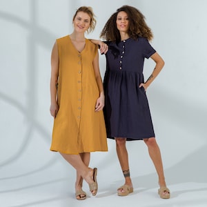 Pu&ograve; includere: Due donne che indossano abiti casual. Una donna indossa un vestito giallo senza maniche con bottoni sul davanti. L'altra donna indossa un vestito blu scuro a maniche corte con bottoni sul davanti.