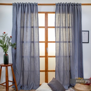 May include: Two gray linen curtains hanging in a window with a wooden frame. The curtains are gathered at the top and have a subtle sheen. The text "metallic grey" is visible in the lower right corner of the image.