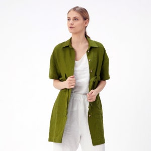 Pu&ograve; includere: Una camicia di lino verde oliva a maniche lunghe con chiusura a bottoni e una cintura in vita.