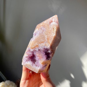 May include: A large, faceted amethyst crystal point with a natural, druzy finish. The crystal is a light purple color with a white, translucent base. The crystal is a natural, raw, and unpolished piece.