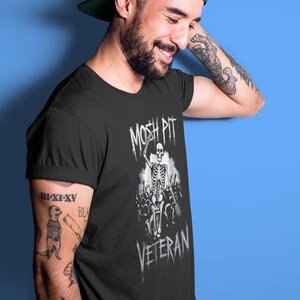 Unleash your rebel spirit with the Mosh Pit Veteran  Featuring a bold skeleton graphic, this edgy streetwear piece is perfect for punk rockers, skaters, and music lovers. Made from durable cotton, it's a must-have for non-conformists!
