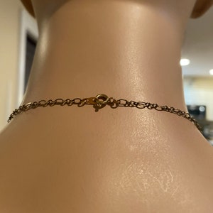 May include: A gold chain necklace with a lobster clasp closure.
