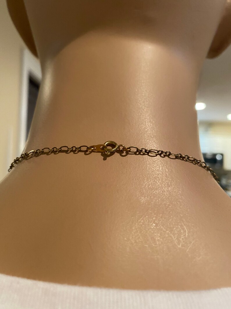 May include: A gold chain necklace with a lobster clasp closure.