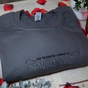May include: A grey sweatshirt with the text "my favourite colour is MORALLY GREY" embroidered on the front.