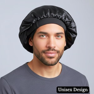 May include: A black satin bonnet with an elastic band. The bonnet is designed for hair protection and is labeled "Unisex Design". The image shows the bonnet on a person.