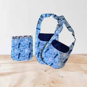 May include: Three-piece set of light blue fabric bags with a repeating pattern of microphones, musical notes, and other music-related icons. The bags have navy blue accents and straps. One bag is a small pouch, and the other two are shoulder bags.
