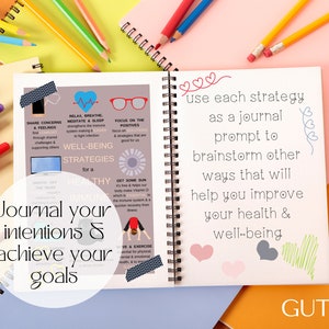 May include: A blue and white journal with the text "Journal your intentions & achieve your goals" and "use each strategy as a journal prompt to brainstorm other ways that will help you improve your health & well-being". The journal is surrounded by colorful pencils and markers.