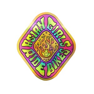 Puede incluir: Una pegatina en forma de diamante con un fondo degradado arcoíris. La pegatina presenta una llama estilizada con estrellas y el texto "Asian Girls Ride Bikes" en un degradado arcoíris.