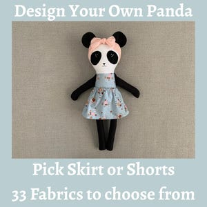 May include: A stuffed panda doll with black limbs and ears, a white face with black eye patches, and a peach-colored headband. The doll wears a light blue dress with a floral pattern. Text reads: Design Your Own Panda, Pick Skirt or Shorts, 33 Fabrics to choose from.
