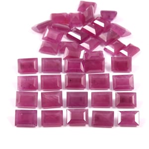 Peut inclure: Une collection de 25 pierres précieuses roses rectangulaires, facettées et non montées. Les pierres précieuses sont disposées en rangées sur une surface blanche.