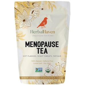 Puede incluir: Una bolsa blanca con un diseño floral amarillo y una ilustración de un pájaro rojo. La bolsa contiene una mezcla de hojas de té sueltas etiquetada como "Menopause Tea" con el texto "HerbalHaven Unique Blend for Women" y "Hot Flashes, Night Sweats, Fatigue". La bolsa también incluye el texto "100% Natural, Caffeine-Free Loose Leaf - 2oz (56g)" y los logotipos "Non-GMO Project Verified" y "USDA Organic". El texto "WWW.HERBALHAVENTEA.COM" está impreso en la parte inferior de la bolsa.