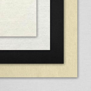 May include: Four different fabric swatches stacked on top of each other. The top swatch is a light beige, the second is black, the third is white, and the bottom swatch is a cream color.