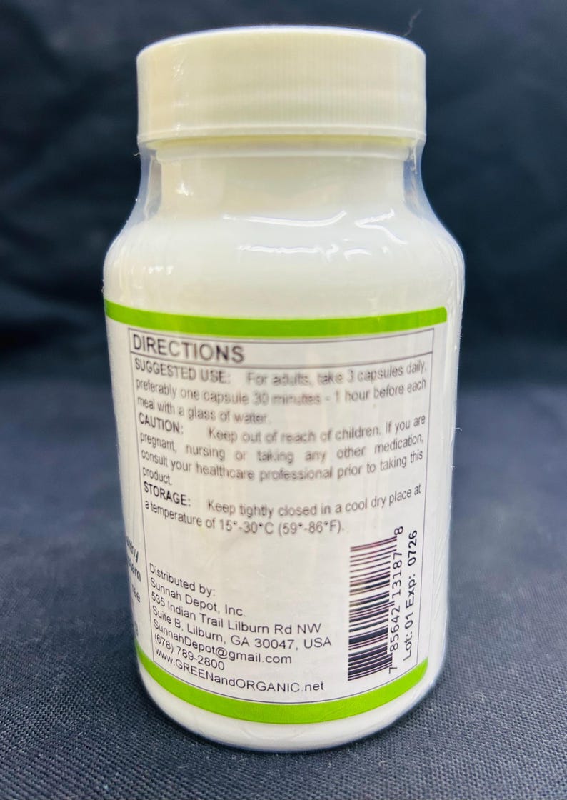 Op de afbeelding: Een witte plastic fles met een witte dop, met capsules. Het etiket bevat gebruiksinstructies, waarschuwingen en bewaarinstructies. De fles is voorzien van de informatie en website van de distributeur.