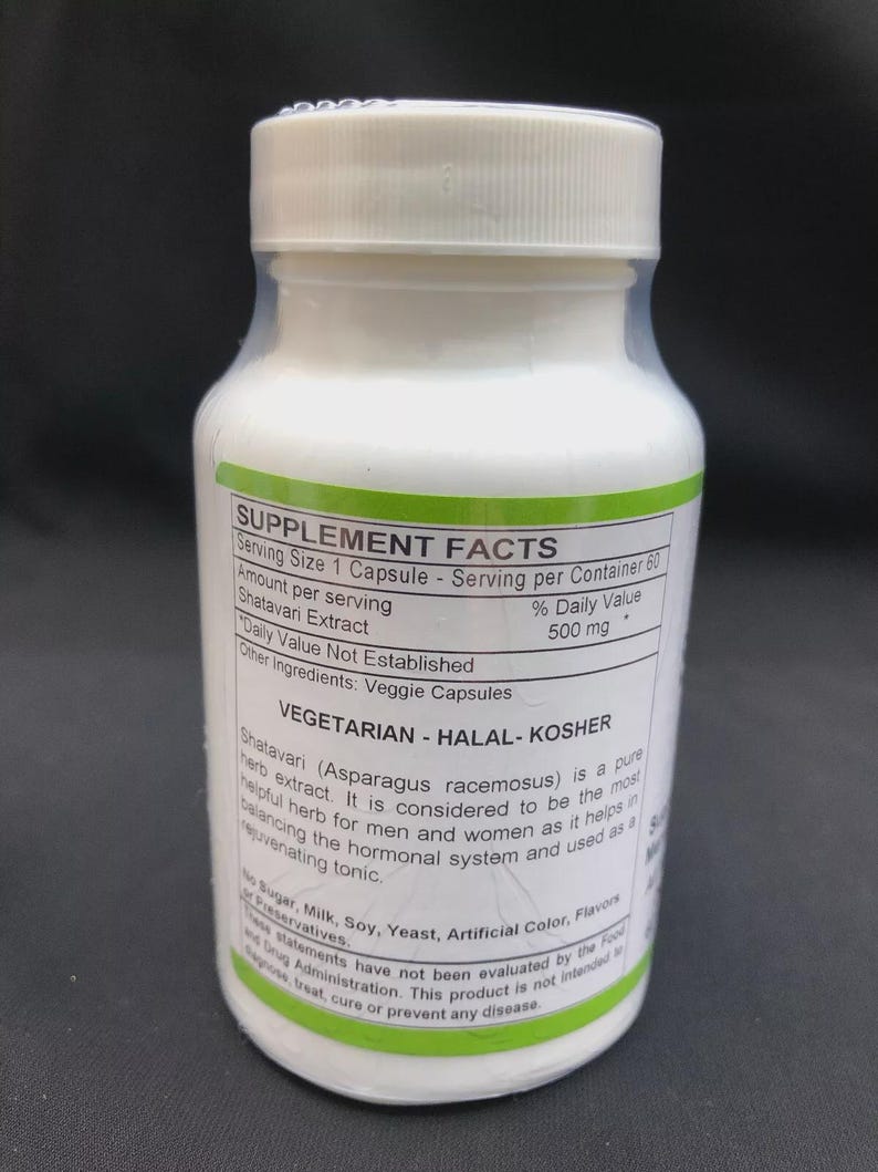 Op de afbeelding: Een witte supplementfles met een witte dop. Het etiket bevat de tekst "SUPPLEMENT FACTS" en "Shatavari Extract 500 mg". De fles is gelabeld als vegetarisch en Halal-Kosher. Het product is een puur kruidenextract.