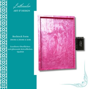 Op de afbeelding: Een rechthoekige roze dienblad met een gladde, glanzende afwerking. Het dienblad meet 30 cm bij 20 cm bij 1 cm. De tekst "Rechteck Form 30cm x 20cm x 1cm" en "Exzellente Oberflächen- und glänzende Seitenflächen- Qualität" staat op de afbeelding.