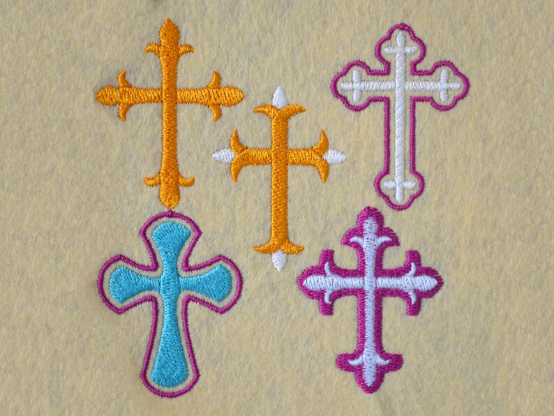 May include: Five embroidered crosses in different colors and styles. The crosses are orange, white, turquoise, and purple.