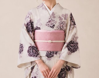 May include: A light beige kimono featuring a repeating pattern of dark purple and muted lavender peony flowers. The garment is secured with a wide, solid dusty pink obi sash, which is fastened with a thin, white decorative cord tied in a knot.