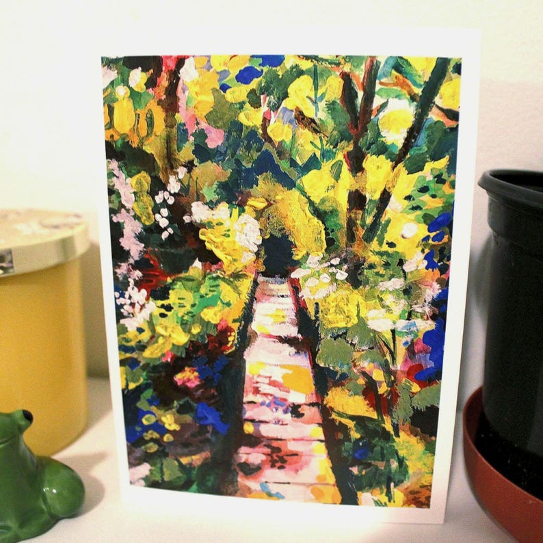 May include: A rectangular greeting card featuring an impressionistic painting of a garden path. The artwork displays vibrant yellow, green, blue, and white brushstrokes depicting lush foliage and flowers flanking a central walkway leading into the distance.