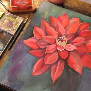 Puede incluir: Pintura de acuarela de una flor roja con un centro amarillo. La flor est&aacute; pintada sobre un fondo azul.