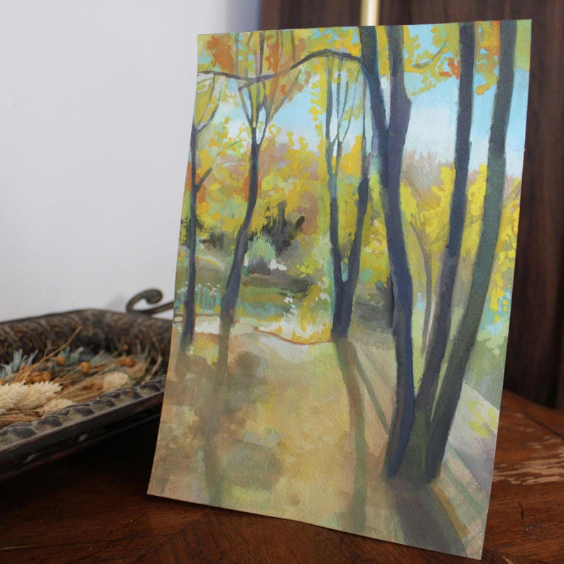 May include: Watercolor painting of a forest scene with tall trees and yellow leaves. The trees are painted in shades of blue and green, and the leaves are a bright yellow. The background is a soft blue.