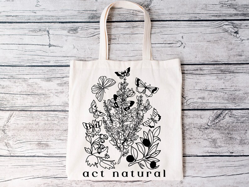 May include: A white tote bag with black line art of flowers, leaves, and butterflies. The text "act natural" is printed at the bottom of the bag.
