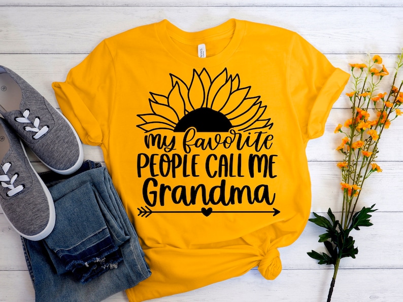 May include: Yellow t-shirt with a black sunflower graphic and the text "my favorite people call me grandma" with a heart and arrows.