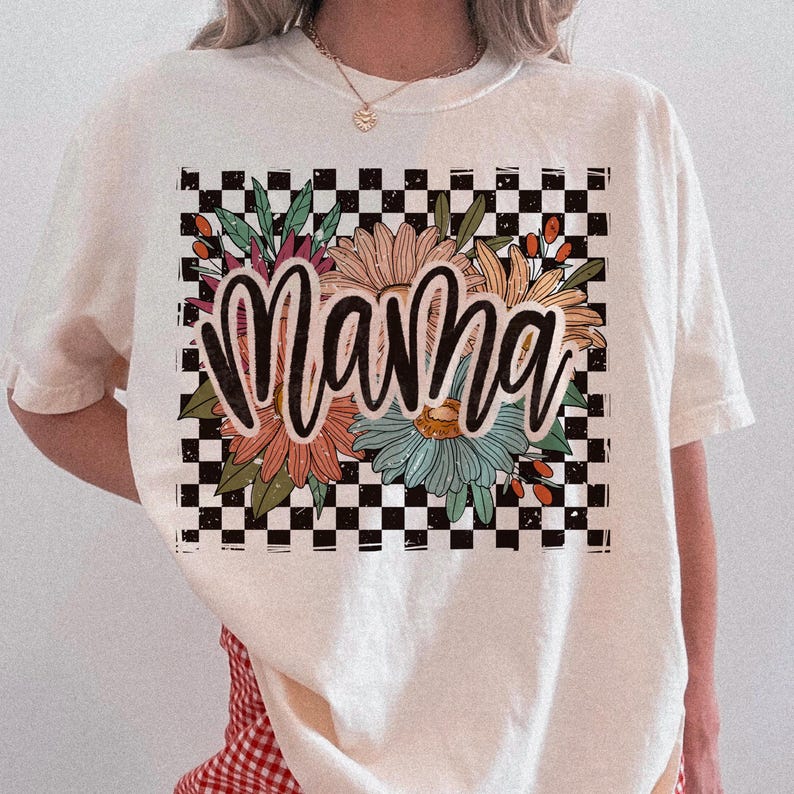 Pode incluir: Camiseta branca com fundo xadrez preto e branco e design floral. A palavra "mama" est&aacute; escrita em letras pretas sobre as flores.