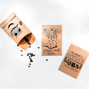 May include: Two brown paper seed packets with black ink illustrations and text. One packet shows a pair of rain boots with flowers growing out of them and the text "grown with love". The other packet shows a watering can with flowers and the text "to plant a garden is to have hope in tomorrow".