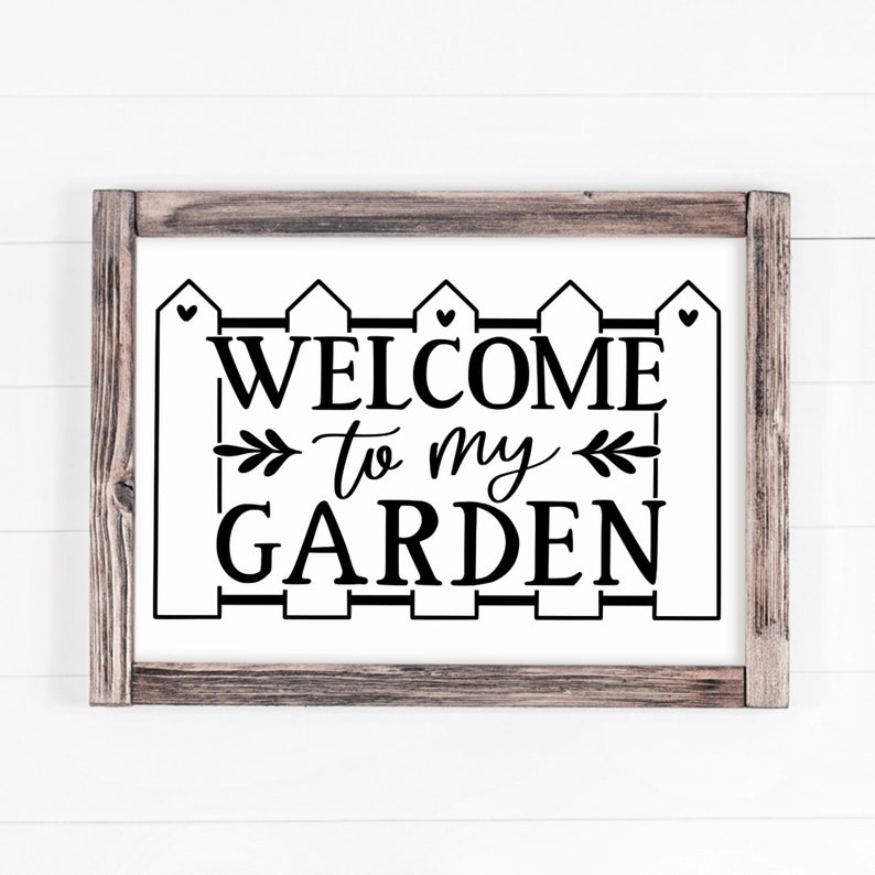 May include: Black and white sign with a picket fence design and the text "Welcome to my Garden".