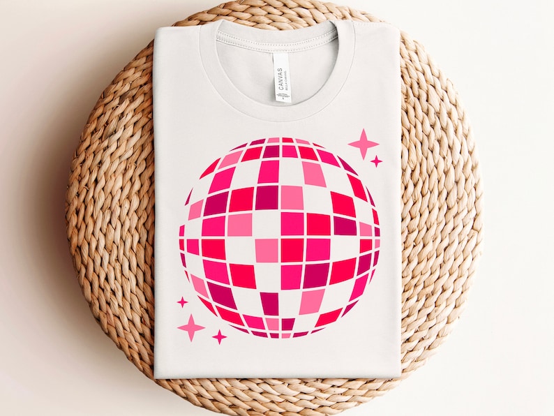 Pu&ograve; includere: Maglietta bianca con una grafica di palla da discoteca rosa e rossa e due piccole stelle rosa.