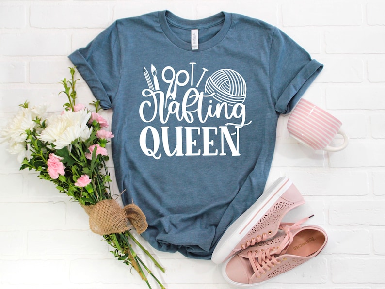 May include: A blue t-shirt with white text that says "Wool Crafting Queen" with a yarn ball and knitting needles graphic.