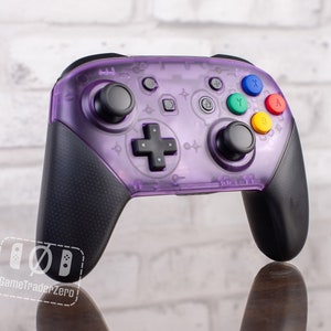 May include: A purple translucent Nintendo Switch controller with black buttons and joysticks. The controller has a clear design, allowing you to see the internal components.
